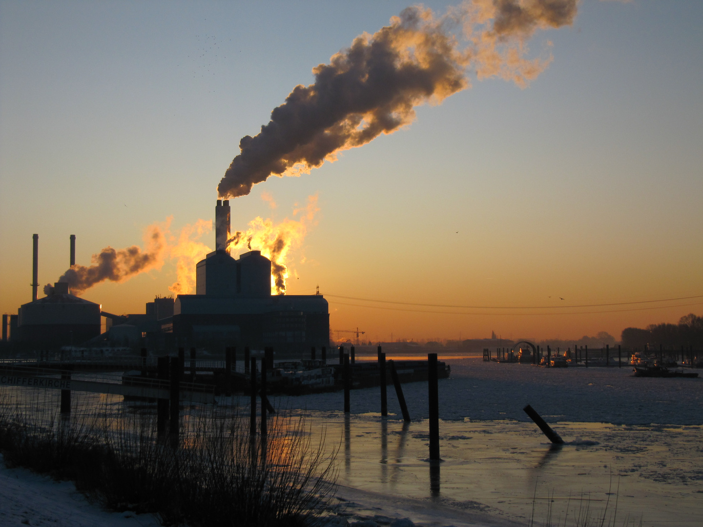 Die Sonne geht hinter dem Kraftwerk Tiefstark in der Billwerderbucht auf