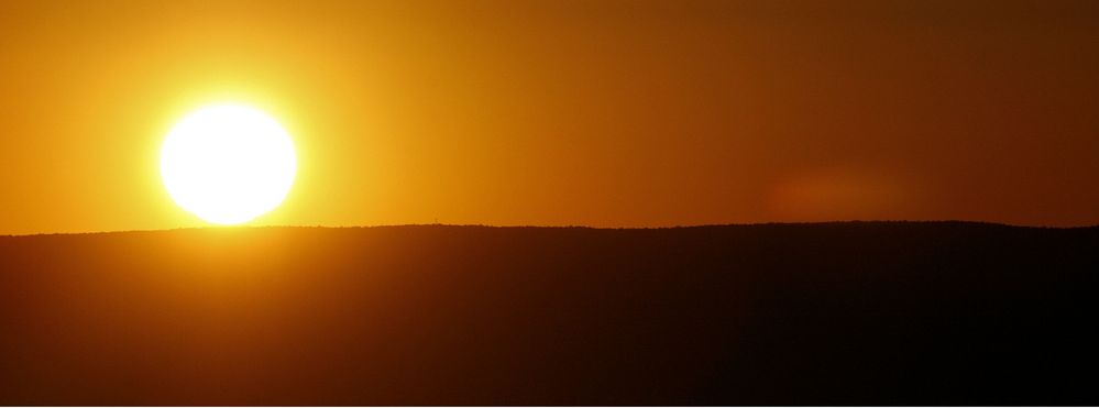 Die Sonne rollt auf einem Felsen im Grand Canyon