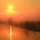 Die Sonne über Nebel und Fluss