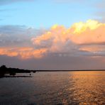 die Strahlen der untergehenden Sonne legen sich aufs Wasser