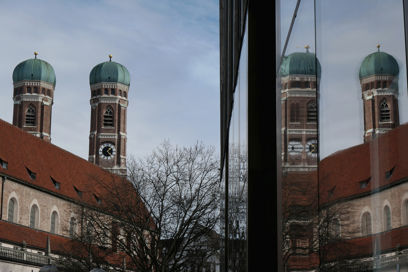 Die Türme der Münchner Frauenkirche spiegeln sich.