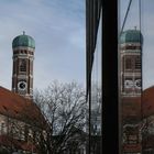 Die Türme der Münchner Frauenkirche spiegeln sich.