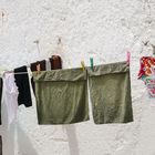 Die Wäsche trocknet an der Hausmauer