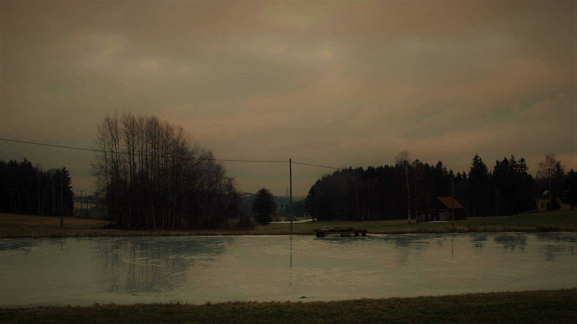 Dienstag ist Spiegeltag : Bäüme und Himmel im Abendlicht auf der Eisfläche im Teich