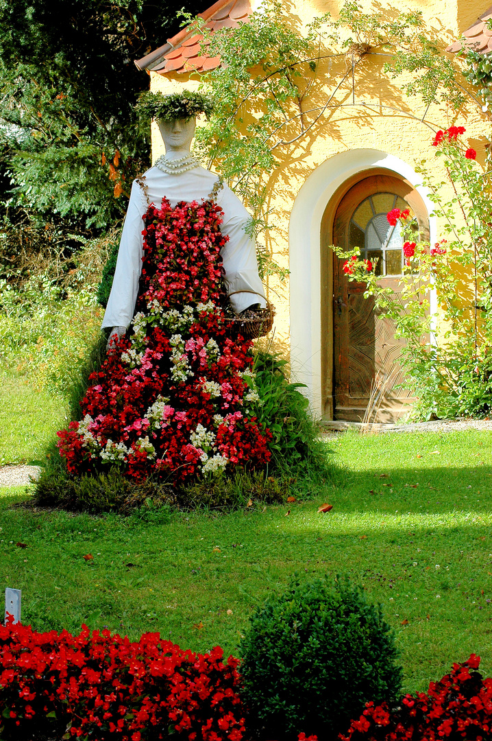 Diese Figur im natürlichen Sommerkleid steht in den Außenanlagen vom Heilbad Krumbad.