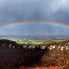 Dorf unter Panorama-Regenbogen