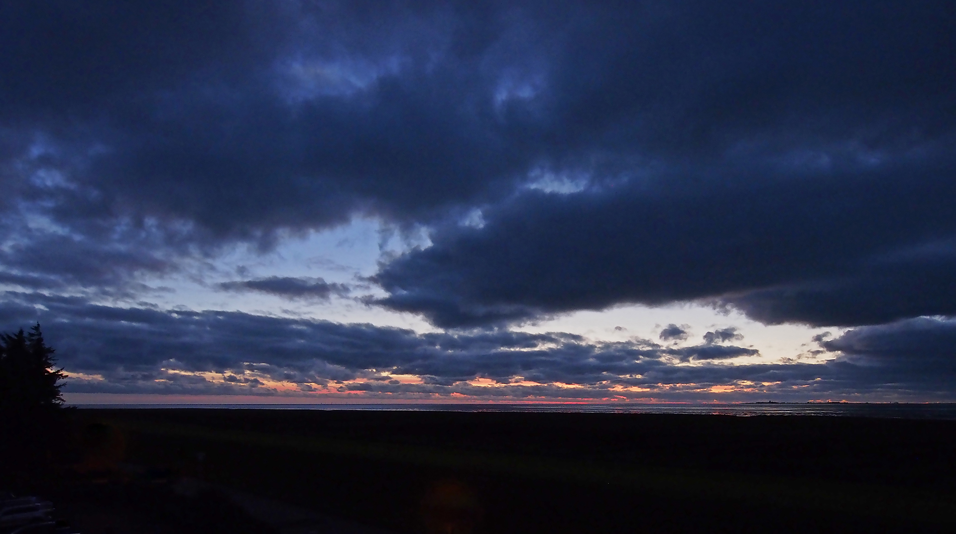 Dramatischer Sonnenuntergang über dem Wattenmeer vor Cuxhaven-Duhnen