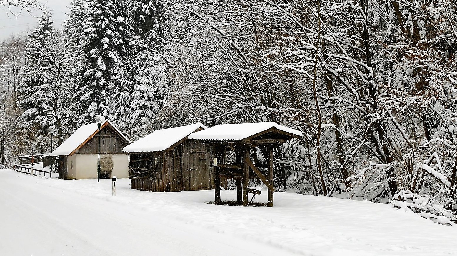 Drei alte bäuerliche Objekte im Schnee