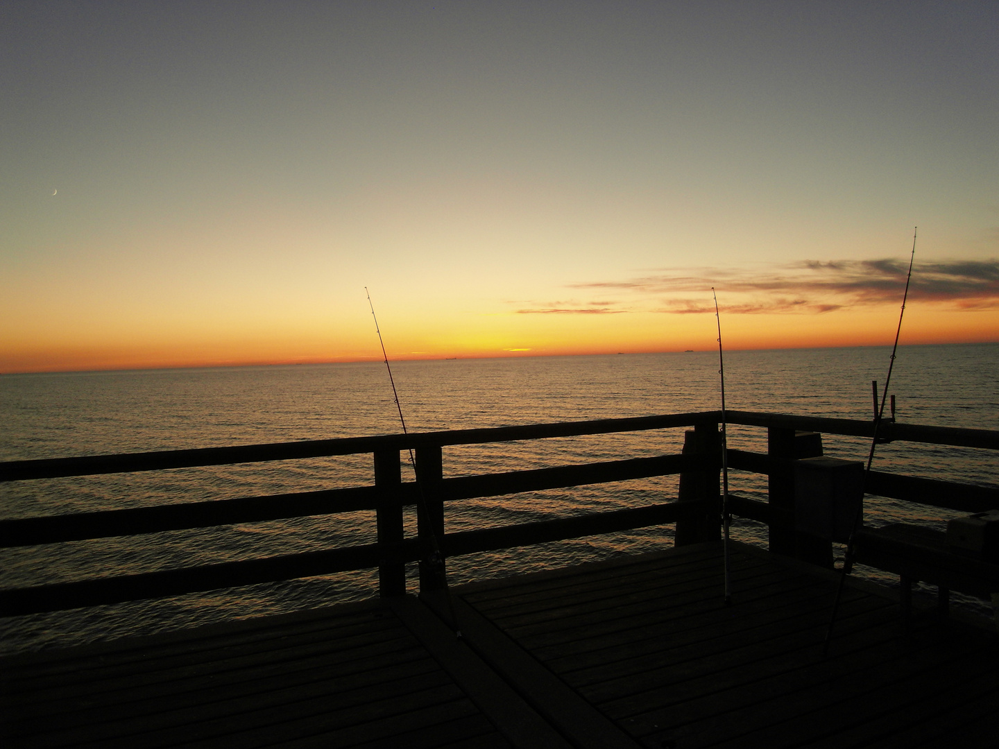 Drei Angelruten bei Sonnenuntergang / Three fishing rods at sunset