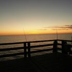 Drei Angelruten bei Sonnenuntergang / Three fishing rods at sunset