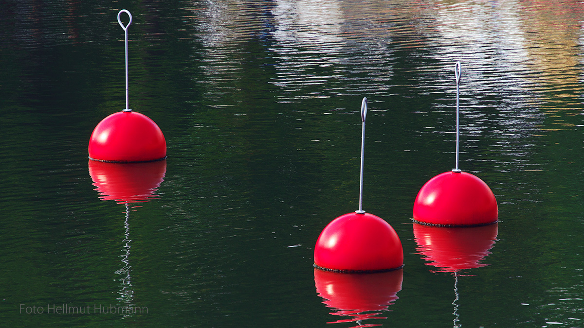 DREI ROTE KUGELN MIT HANDGRIFF NOCH IM WASSER