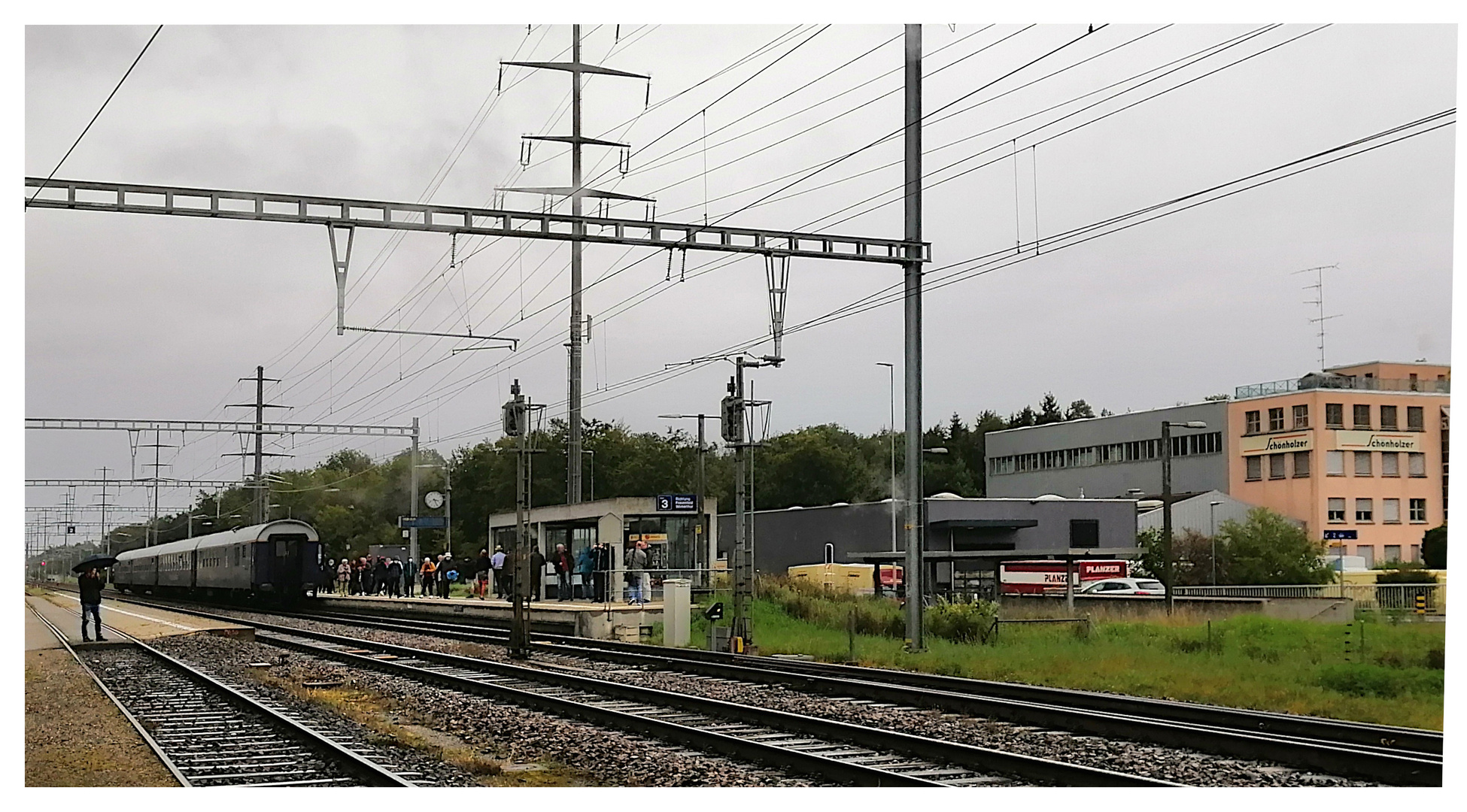 Drei Wagen, und viele Mitreisende,  warten auf die Dampflok