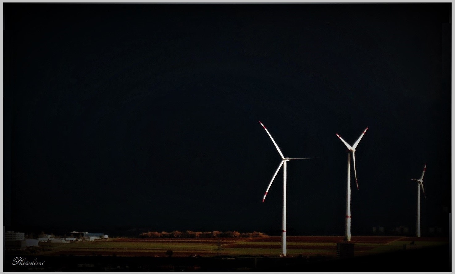 Drei Windräder im letzten Tageslicht