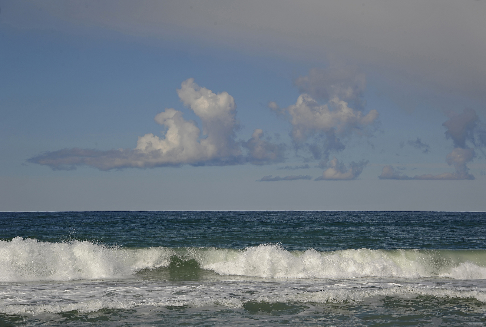 Dreifache Quellwolkenformation mit gerader Unterkante an der dänischen Nordseeküste von Midtjylland