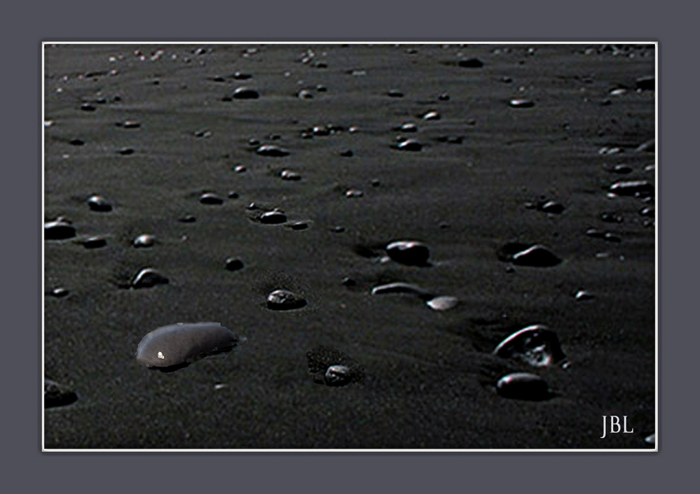 Du sable et des galets noirs