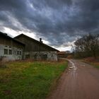 Dunkle Wolken liegen über dem Gehöft