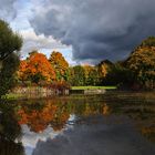 dunkle Wolken über dem herbstlichen Weiher