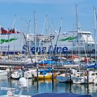 Durch die Segelmasten auf das Fährschiff geblickt wie es in den Hafen von Warnemünde fährt,…