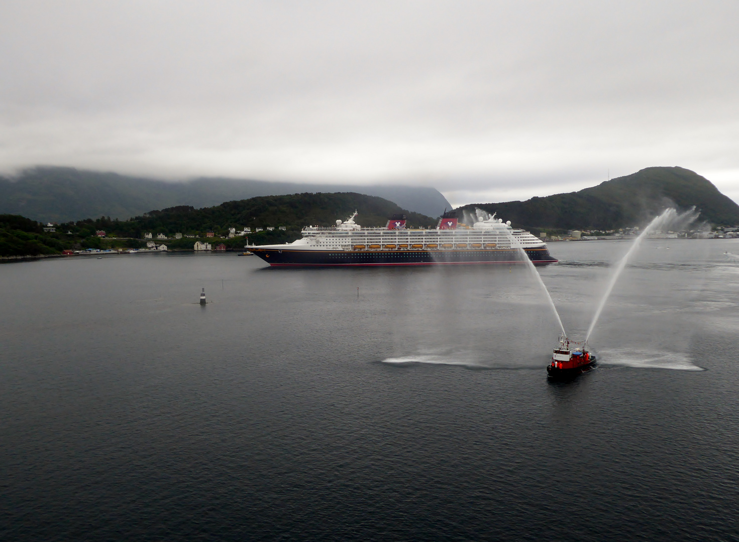 Durch Wasserfontänen wird  die Disney Majestic im Hafen von Tromsö verabschiedet