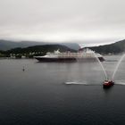 Durch Wasserfontänen wird  die Disney Majestic im Hafen von Tromsö verabschiedet