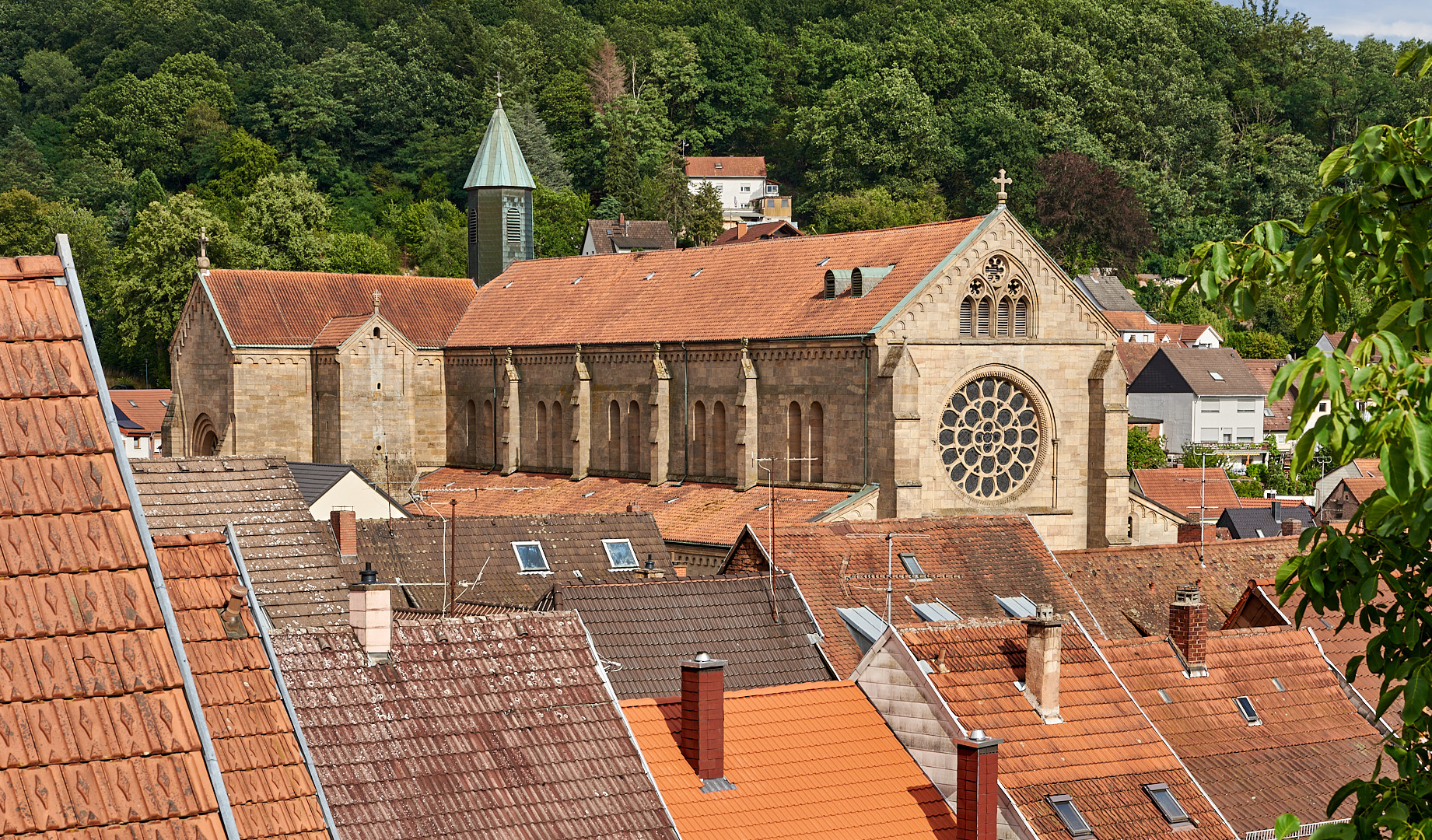 Durchblick mit Blick über die Dächer von der Altstadt Otterberg auf die Abteikirche