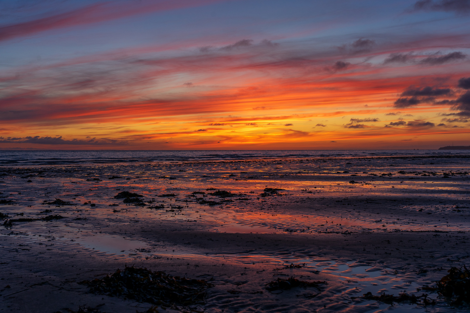 Ebbe und Sonnenuntergang am Strand