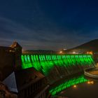 Edertalsperre in grüner Illumination mit Sternenhimmel.