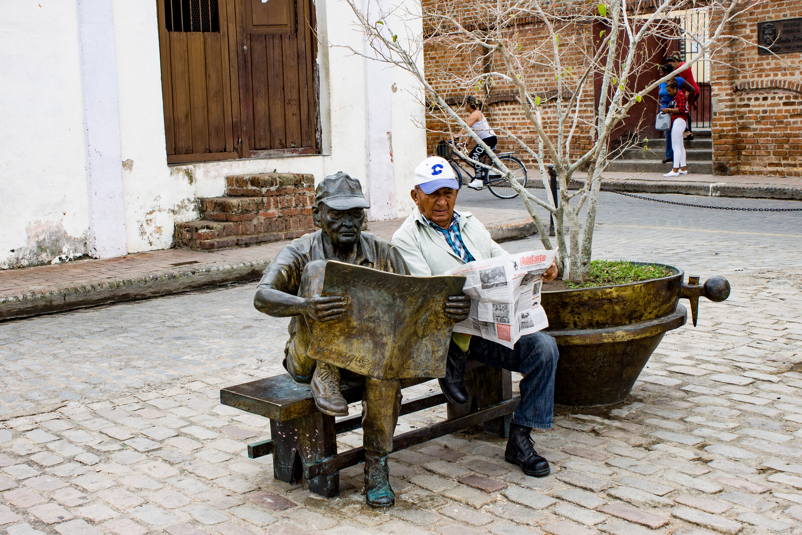 Ein alter Mann mit seiner Bronze Statue in Camagüey 