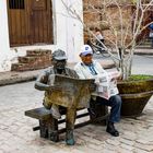 Ein alter Mann mit seiner Bronze Statue in Camagüey 