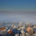Ein Dorf erstrahlt über dem Nebel