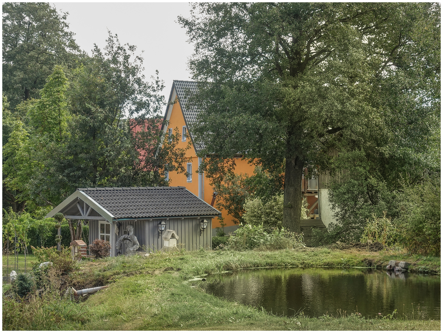 ein ehrbares Dorfhaus mit Gartenteich