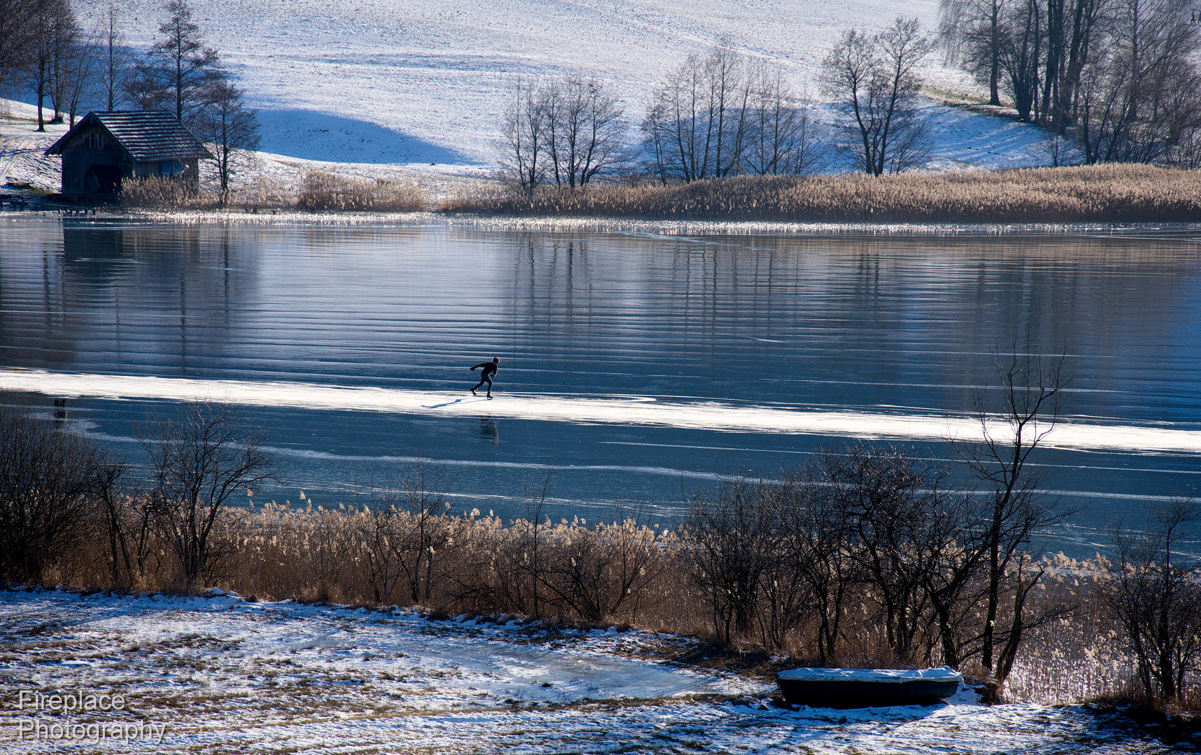 Ein einsamer Eisläufer am Irrsee