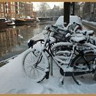 Ein Fahrrad unter Schnee in Amsterdam