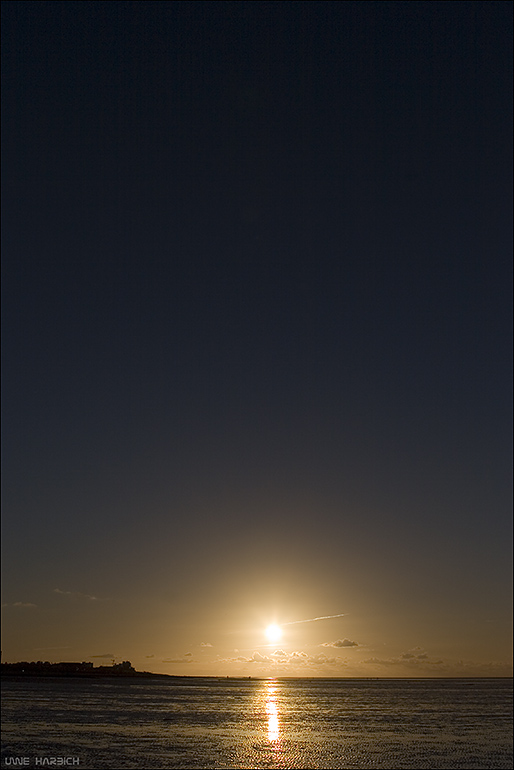 ein fast wolkenloser sonnenuntergang über dem watt