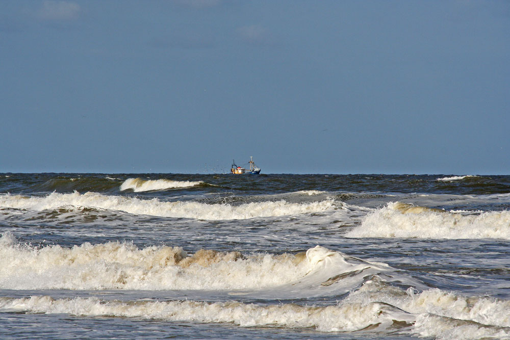 ...ein Fischerboot kämpft sich durch die Wellen