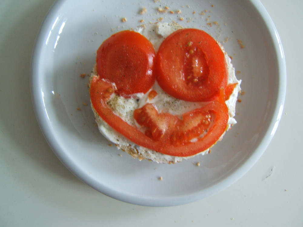 Ein Frühstücksbrot mit Frischkäse und Tomaten