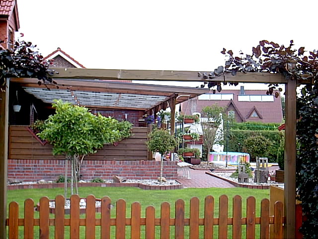 ein Garten mit überdachter Terrasse