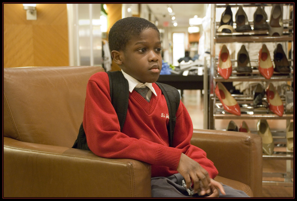 Ein Jungen wartet auf seine Mutter im Laden in New York