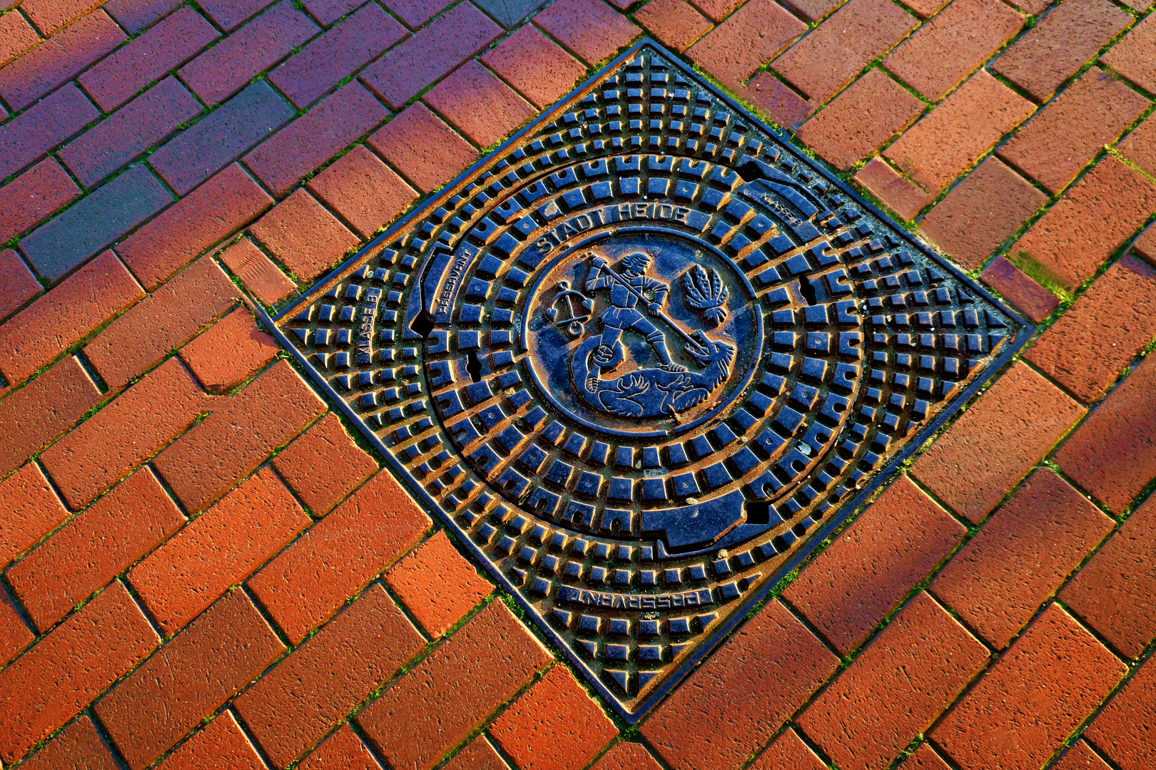 Ein Kanaldeckel der Stadt Heide mit dem Bildnis des heiligen Georg