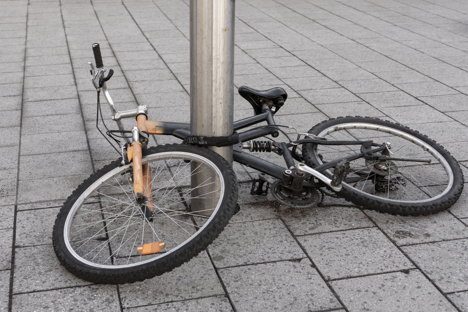 Ein kaputtes Fahrrad an der Säule befestigt
