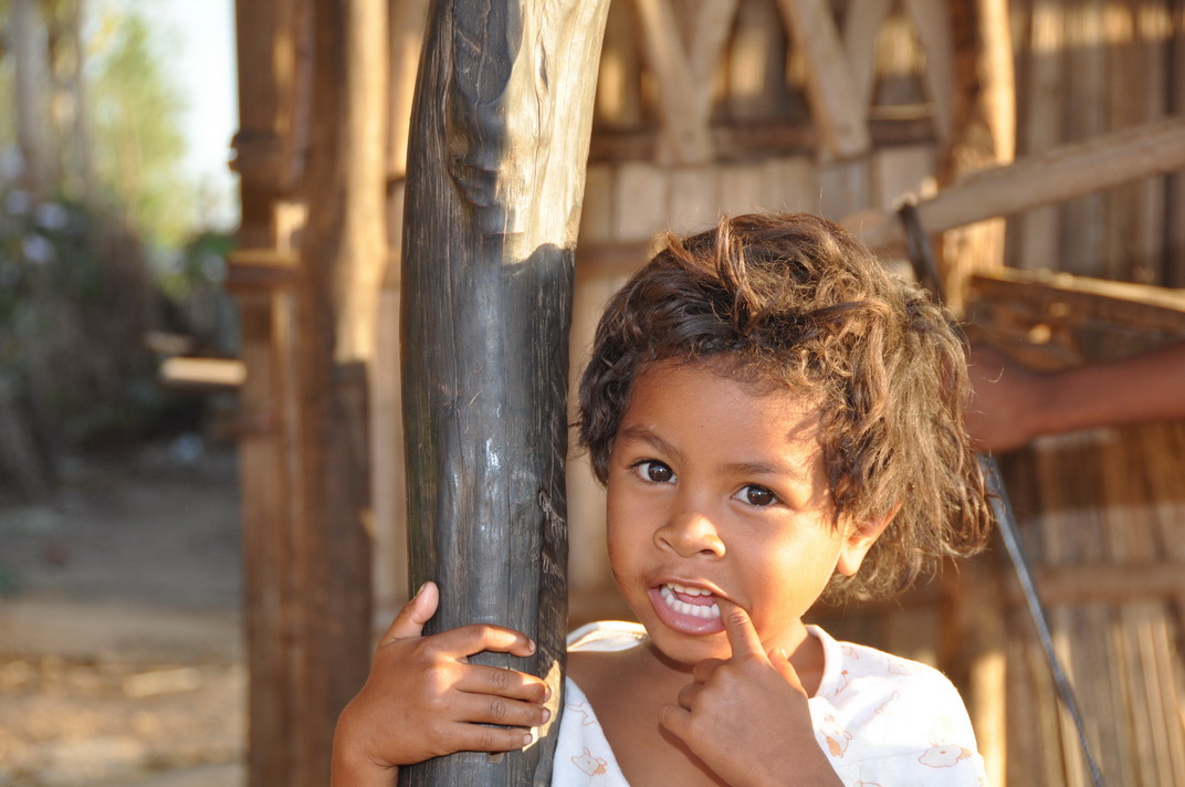 Ein Kind auf dem Land mit dem Haus aus Satrana in Nord Madagaskar