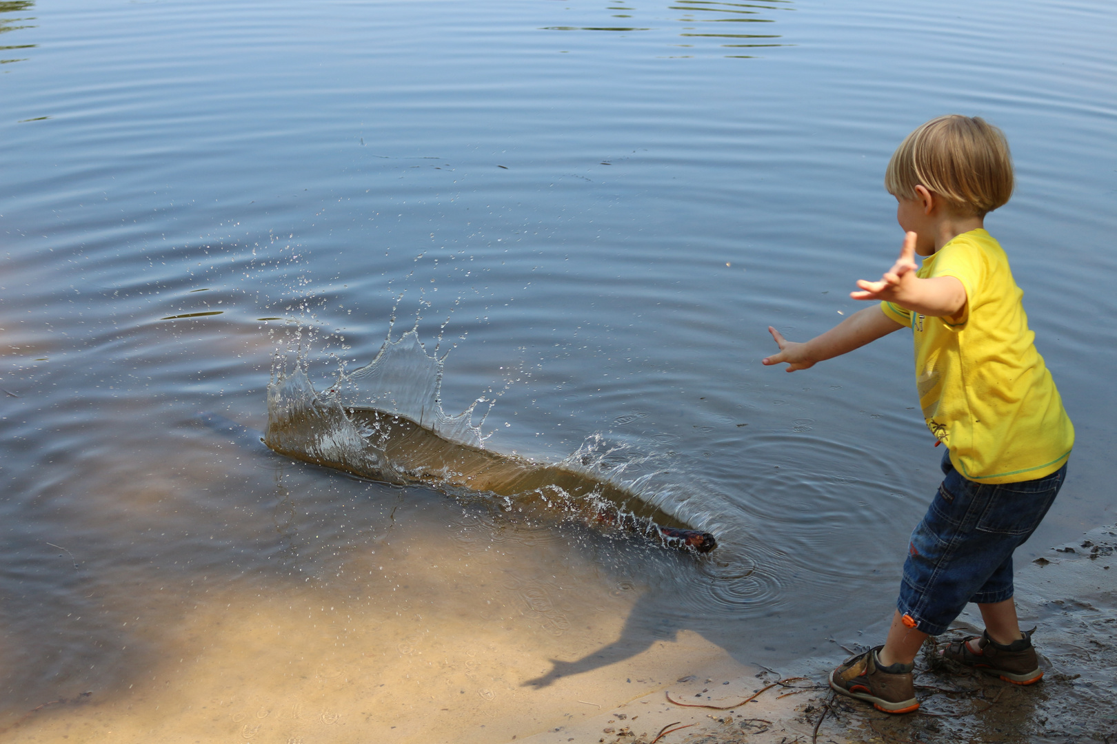 Ein Kind, Wasser und ein Stock