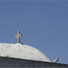 ein Kreuz, eine Taube und der blaue Himmel über Mykonos