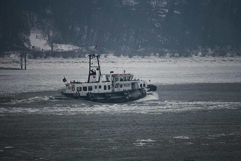 Ein Lotsenboot kämft sich durch das Eiswasser der Elbe