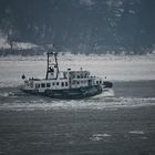 Ein Lotsenboot kämft sich durch das Eiswasser der Elbe