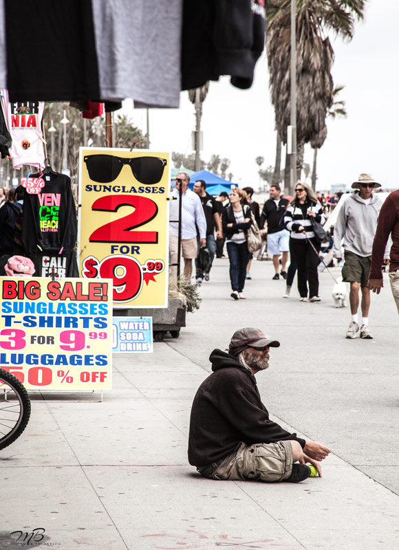 Ein Mann, der sich an der Strandpromenade des Venice Beach in Los Angeles ausruht.