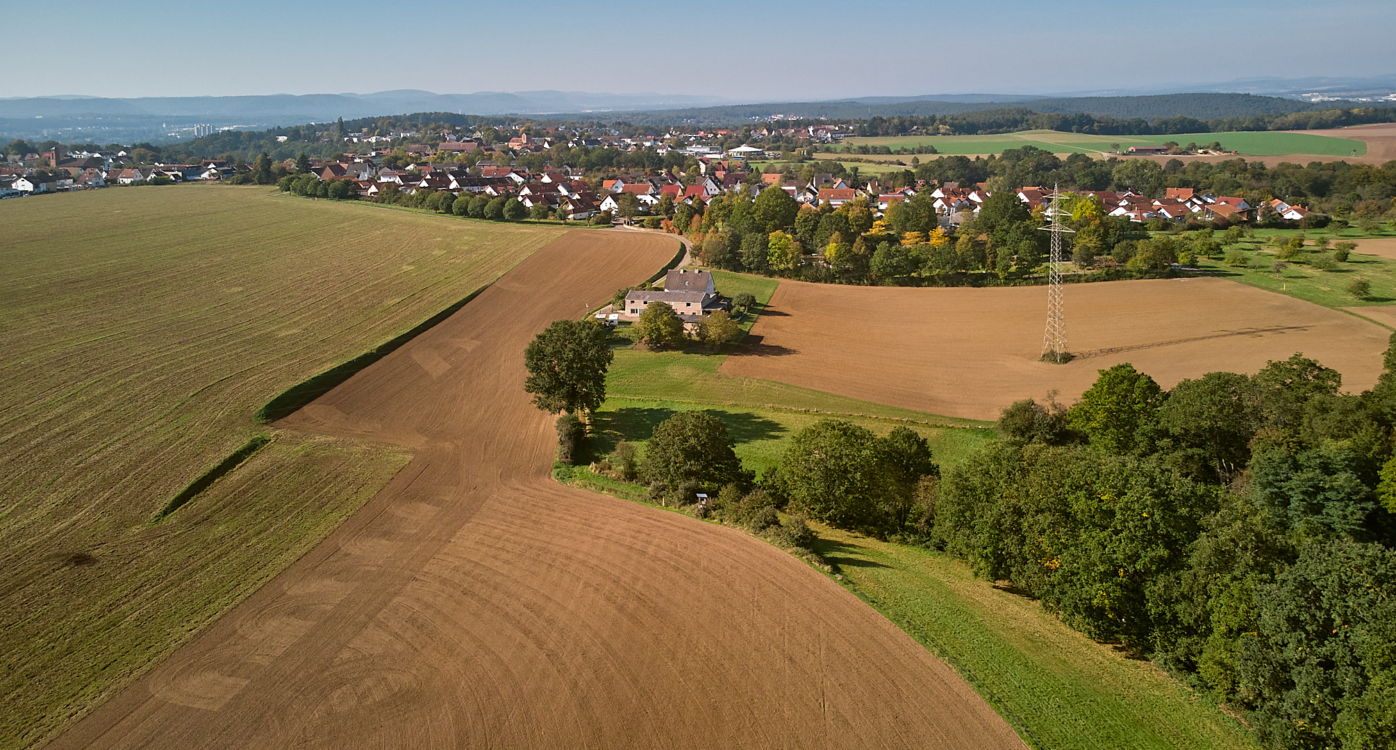 Ein Pfälzer in die Lüfte steigt, von oben seinen Wohnort im Morgenlicht zeigt.