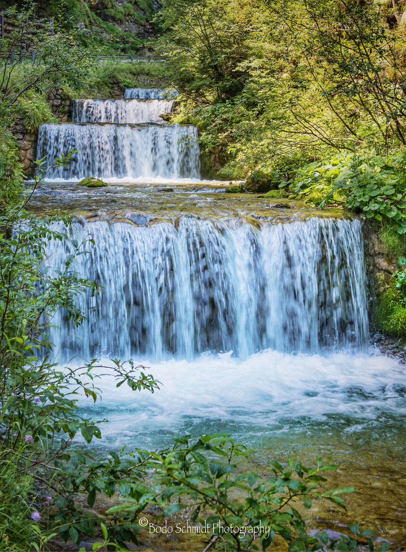 Ein sauberer Gebirgsfluss strömt in Kaskaden zu Tal