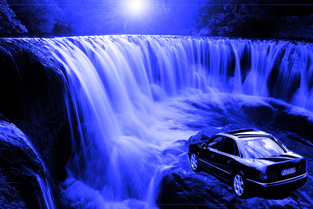 Ein schönes Auto vor einem schönen Wasserfall