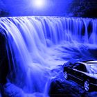 Ein schönes Auto vor einem schönen Wasserfall